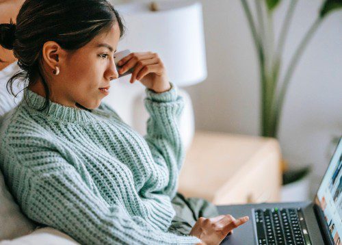 Young female working on laptop sitting on steps