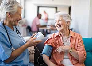 a health worker taking blood pressure from woman