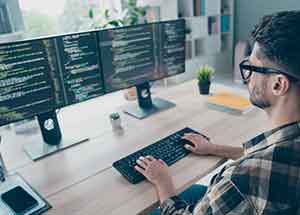 Student behind a desk with code