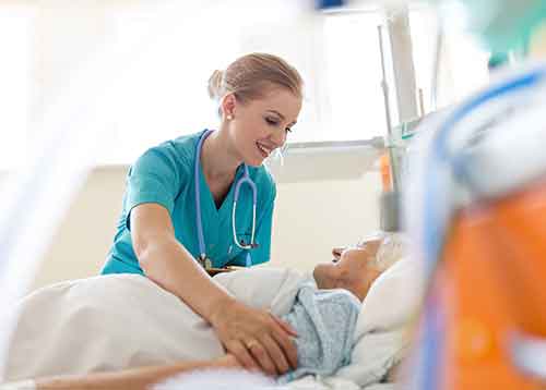 Nurse caring for elderly patient on bed