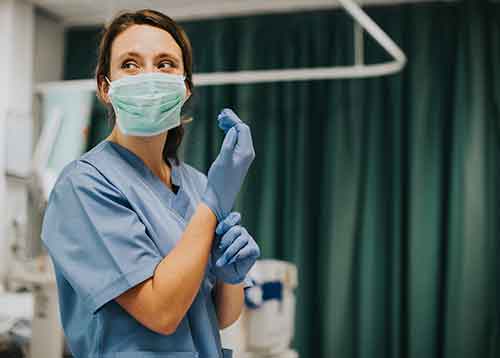 Nurse putting on gloves