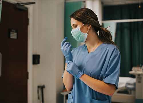 Nurse putting on gloves